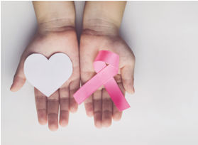 hand holding a pink ribbon and grey heart.